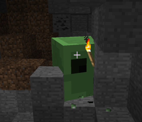 Screenshot of alpha minecraft. A slime in a nook within the wall of a cave. A torch is placed in front of it.